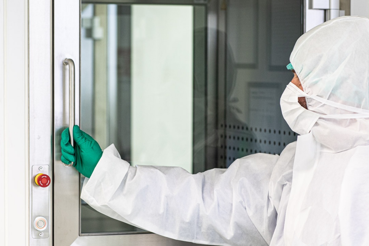 Tehnician deschizând uşă către echipamentele laboratorului